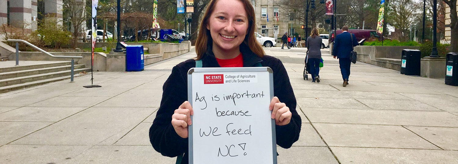 Shelby Ferrel holding a sign explaining why agriculture is important.
