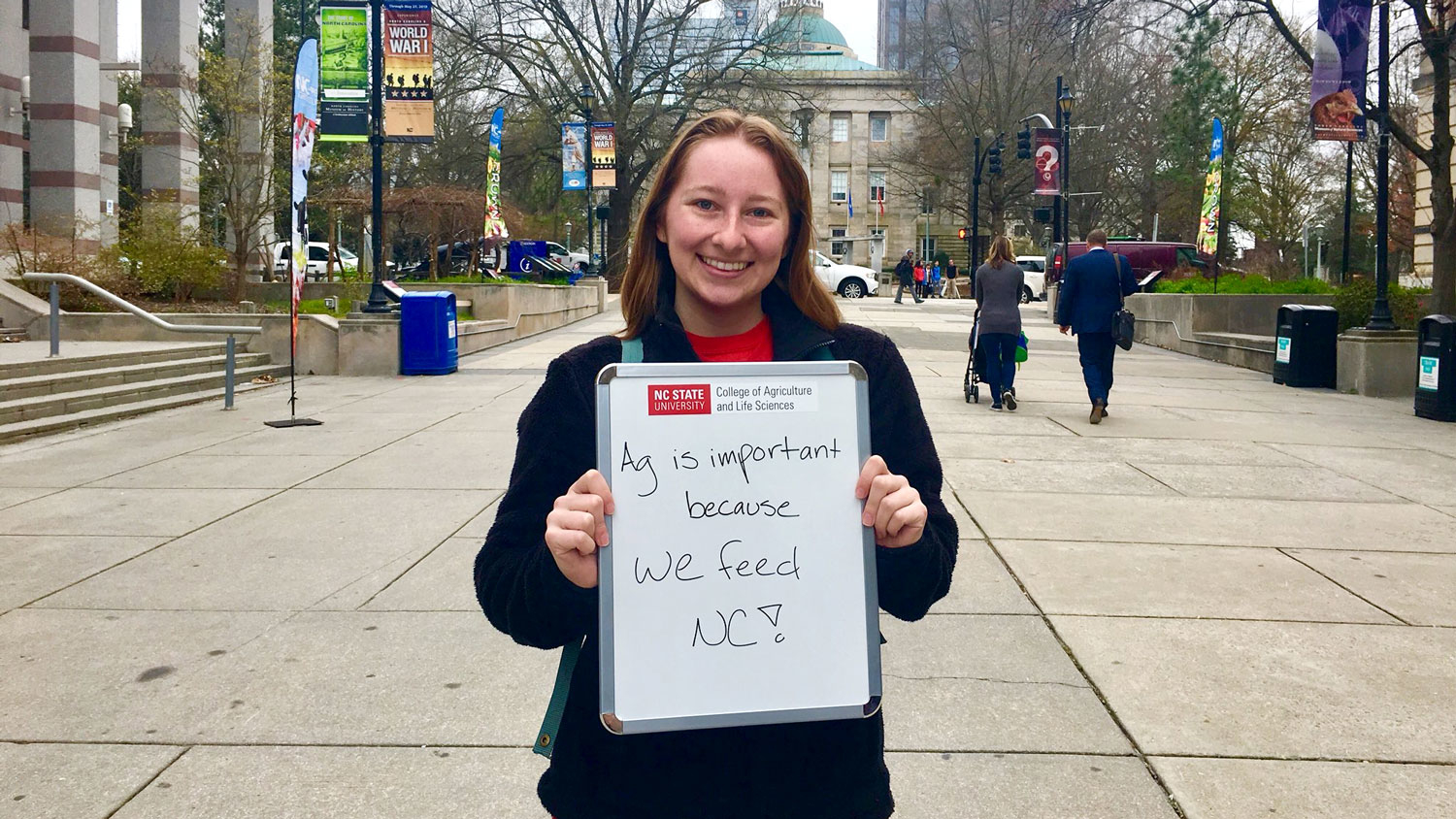 Shelby Ferrel holding a sign explaining why agriculture is important.